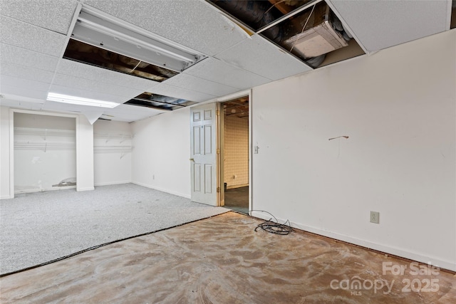 finished below grade area with a drop ceiling and baseboards
