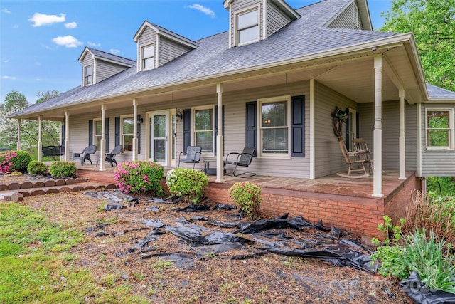 view of front facade featuring roof with shingles and covered porch