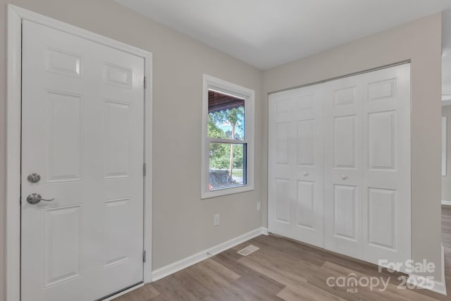 unfurnished bedroom with wood finished floors, baseboards, and a closet