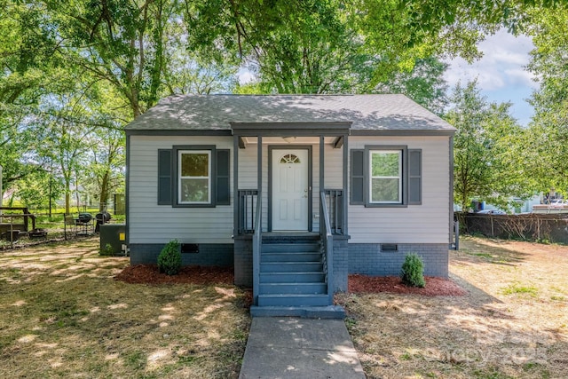 bungalow-style house with crawl space, fence, and roof with shingles
