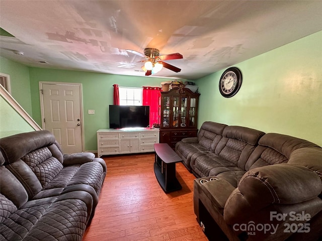 living area with wood-type flooring and a ceiling fan