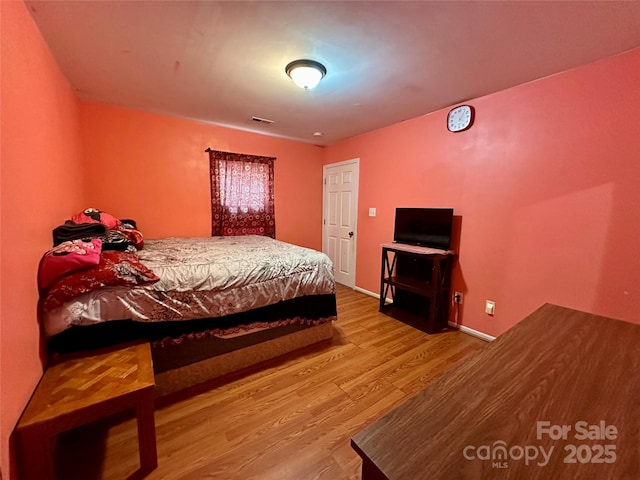 bedroom with visible vents and wood finished floors