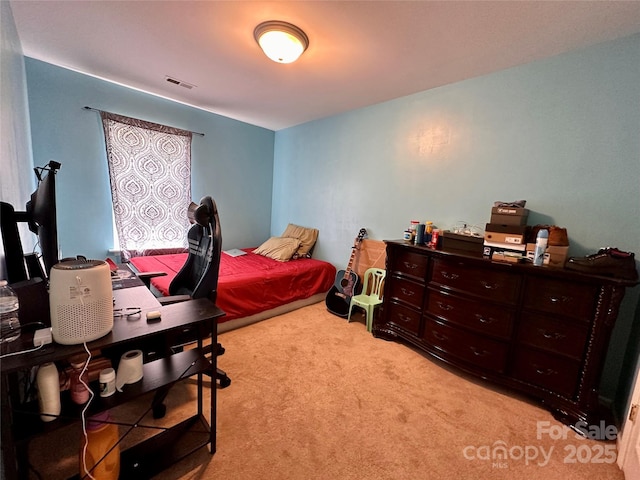 bedroom with visible vents and light carpet