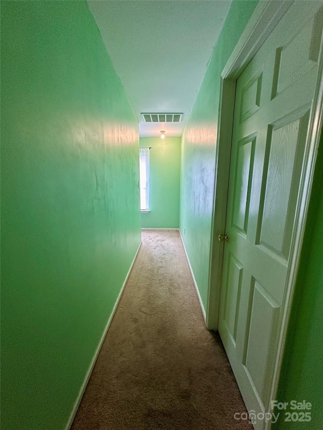 hall featuring visible vents, baseboards, and carpet