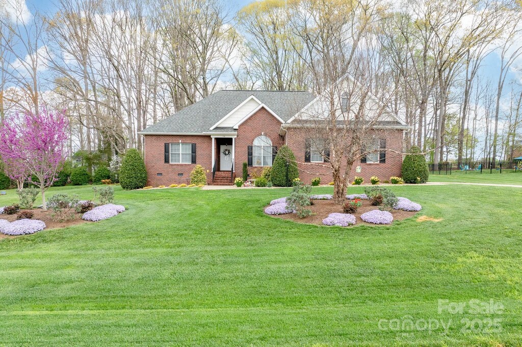 ranch-style home with crawl space, a front lawn, and brick siding