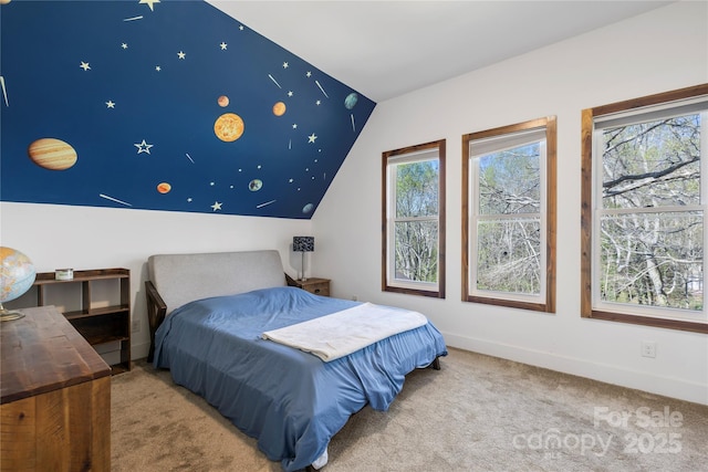 carpeted bedroom featuring baseboards and vaulted ceiling