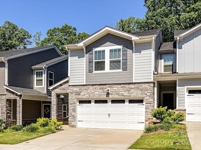 view of front of property with stone siding, an attached garage, and concrete driveway