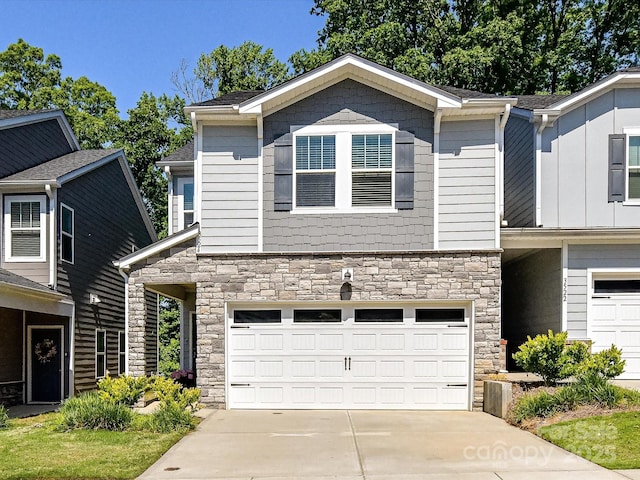 view of front of property with stone siding, a garage, and driveway