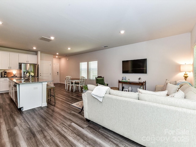 living area featuring dark wood-style flooring and recessed lighting
