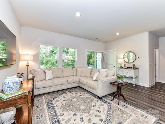 living room with wood finished floors, baseboards, and recessed lighting