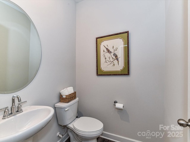 half bathroom featuring a sink and toilet