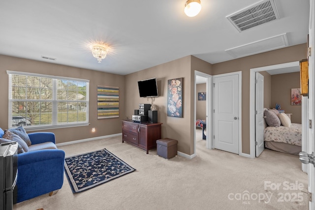 living area featuring baseboards, visible vents, light colored carpet, and attic access