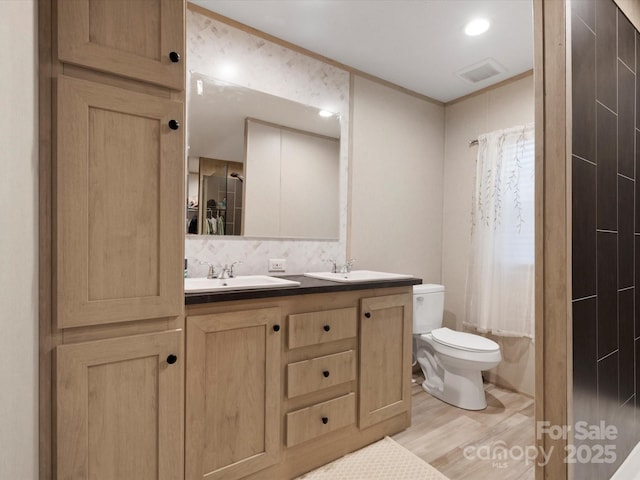 2234 Emerald Mine Rd, Shelby, NC 28152 - bathroom with a sink, double vanity, toilet, visible vents, and wood finished floors