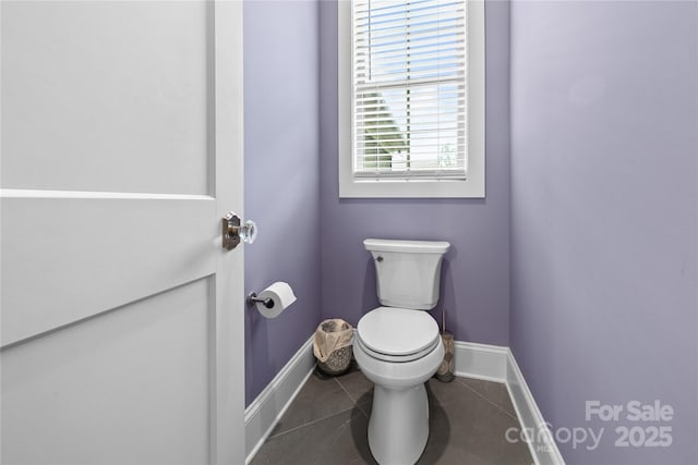 bathroom with toilet, tile patterned floors, and baseboards
