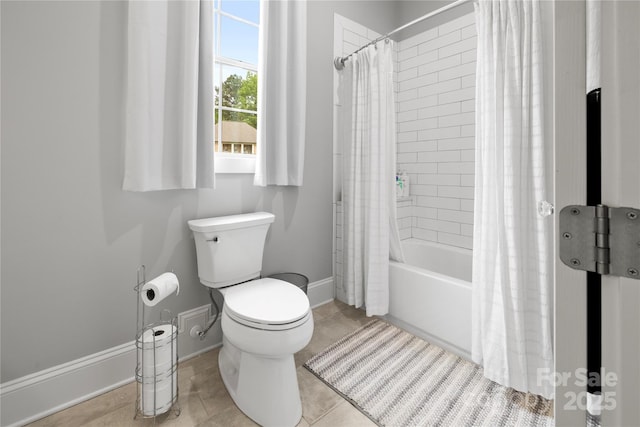 full bath with toilet, tile patterned floors, baseboards, and shower / bath combo