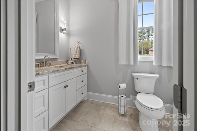 bathroom with vanity, baseboards, and toilet