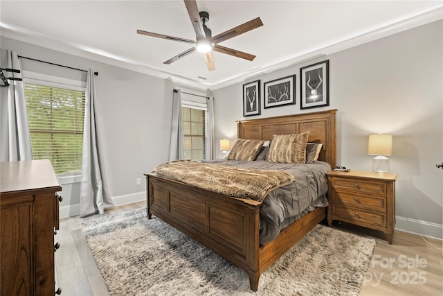 bedroom with light wood-style flooring, baseboards, and a ceiling fan
