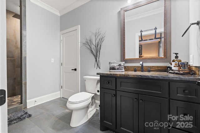 bathroom featuring a tile shower, vanity, ornamental molding, toilet, and baseboards