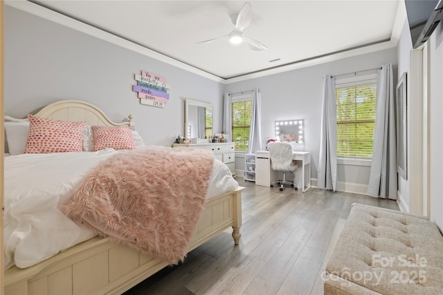 bedroom with visible vents, baseboards, a ceiling fan, light wood-style floors, and crown molding