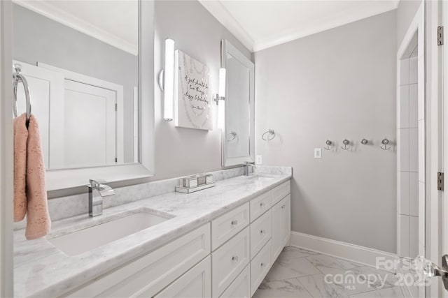 bathroom with baseboards, a sink, crown molding, double vanity, and marble finish floor