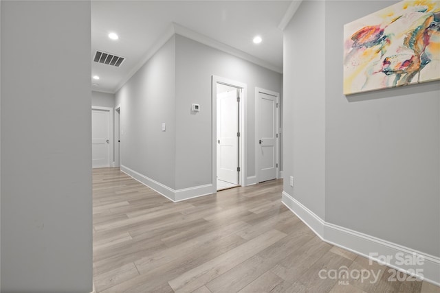 hallway featuring light wood finished floors, baseboards, visible vents, and recessed lighting