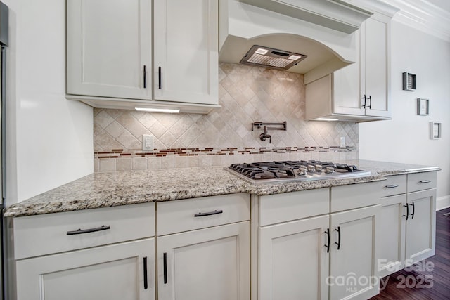 141 Forsythia Ln, Tega Cay, SC 29708 - kitchen with custom exhaust hood, white cabinets, dark wood-style flooring, light stone countertops, and stainless steel gas cooktop