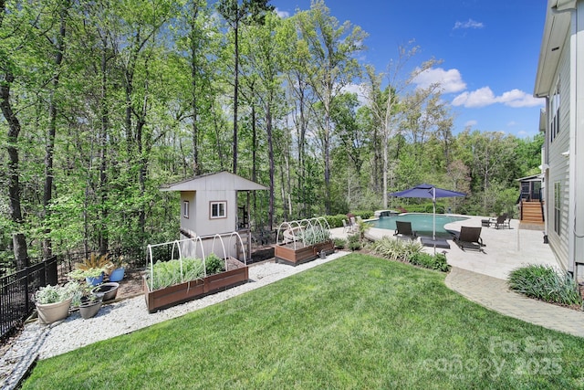 141 Forsythia Ln, Tega Cay, SC 29708 - view of yard featuring a vegetable garden, an outdoor structure, a patio, fence, and a fenced in pool