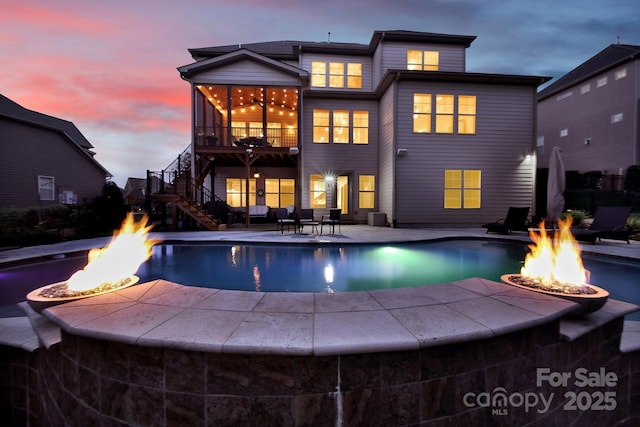 141 Forsythia Ln, Tega Cay, SC 29708 - back of house at dusk featuring an outdoor pool, a patio area, a fire pit, and stairway