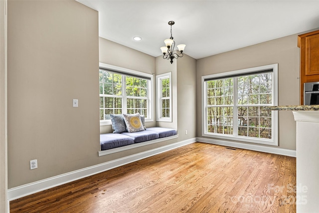 sitting room with baseboards, an inviting chandelier, and plenty of natural light