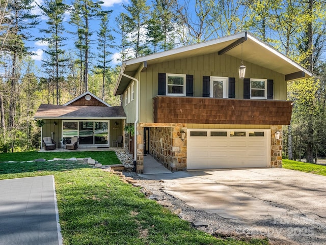 4075 Little River Rd, Hendersonville, NC 28739 - view of front facade featuring stone siding, a garage, concrete driveway, and a front yard