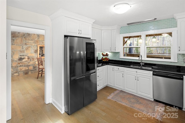 4075 Little River Rd, Hendersonville, NC 28739 - kitchen featuring appliances with stainless steel finishes, dark countertops, light wood-style floors, white cabinetry, and backsplash
