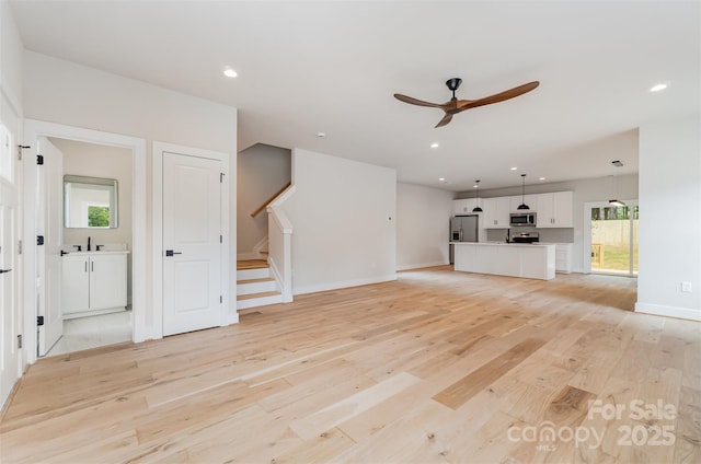 2512 Remington St, Charlotte, NC 28216 - unfurnished living room featuring ceiling fan, stairway, light wood-style flooring, healthy amount of natural light, and recessed lighting