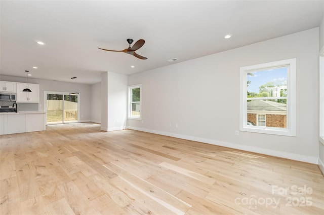 2512 Remington St, Charlotte, NC 28216 - unfurnished living room with a ceiling fan, plenty of natural light, light wood-type flooring, baseboards, and recessed lighting