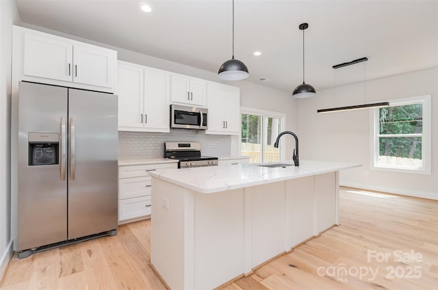 2512 Remington St, Charlotte, NC 28216 - kitchen featuring appliances with stainless steel finishes, a sink, light wood-style floors, white cabinets, and backsplash
