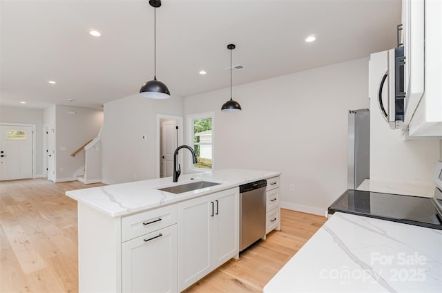 2512 Remington St, Charlotte, NC 28216 - kitchen featuring appliances with stainless steel finishes, a sink, light wood-style flooring, white cabinets, and light stone counters