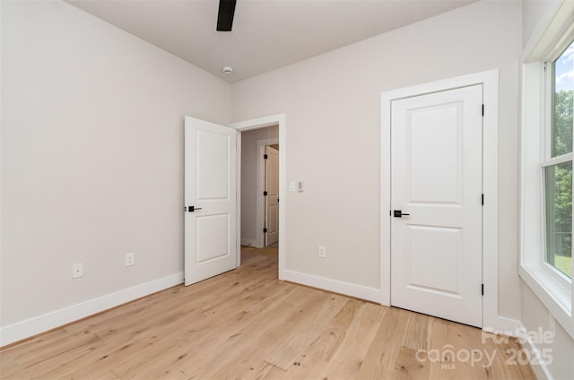 2512 Remington St, Charlotte, NC 28216 - unfurnished bedroom featuring light wood-style flooring, baseboards, multiple windows, and a ceiling fan