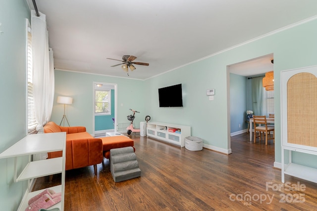 living area featuring crown molding, ceiling fan, wood finished floors, and baseboards