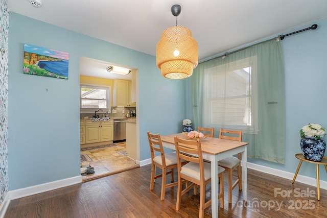 dining space featuring baseboards and light wood finished floors