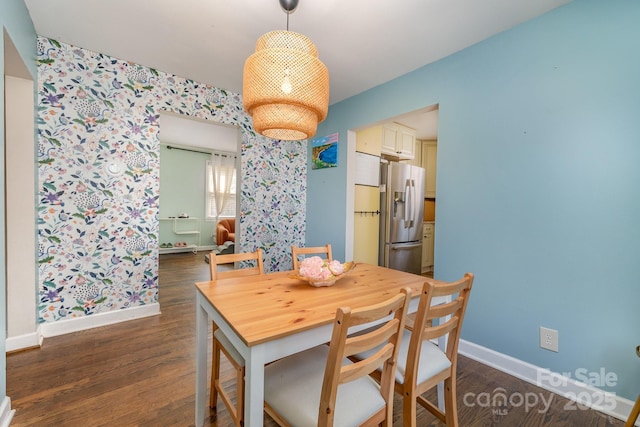 dining space featuring baseboards, wallpapered walls, and dark wood finished floors