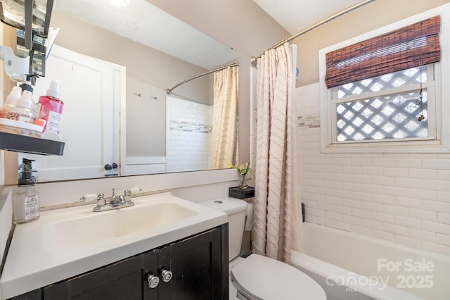 full bath featuring toilet, vanity, and shower / tub combo with curtain