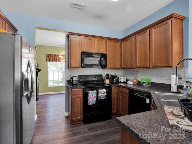 5102 Candleglow Ct, Indian Trail, NC 28079 - kitchen with dark countertops, visible vents, dark wood-style floors, and black appliances