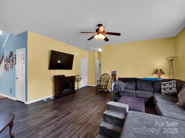5102 Candleglow Ct, Indian Trail, NC 28079 - living room featuring stairs, a glass covered fireplace, baseboards, ceiling fan, and dark wood-type flooring