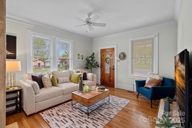 living room featuring crown molding, ceiling fan, light wood-style flooring, baseboards, and visible vents