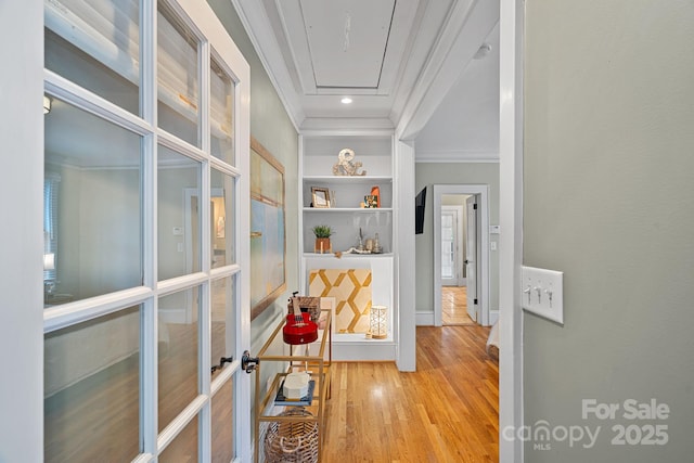 hallway featuring baseboards, ornamental molding, french doors, and wood finished floors