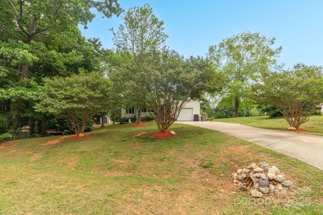 obstructed view of property with driveway and a front yard