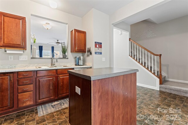 12905 Bullock Greenway Blvd, Charlotte, NC 28277 - kitchen featuring stone finish floor, a ceiling fan, a kitchen island, a sink, and baseboards