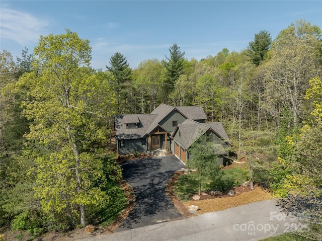 29 Wild Deer Trl, Zirconia, NC 28790 - rustic home featuring driveway, board and batten siding, a view of trees, roof with shingles, and an attached garage