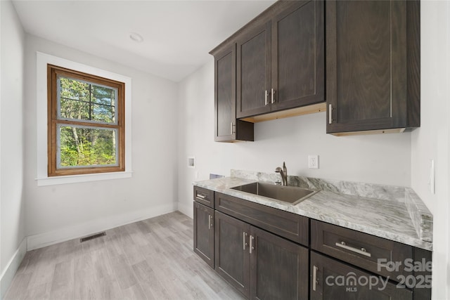 29 Wild Deer Trl, Zirconia, NC 28790 - kitchen featuring dark brown cabinetry, light wood-style floors, and light stone counters