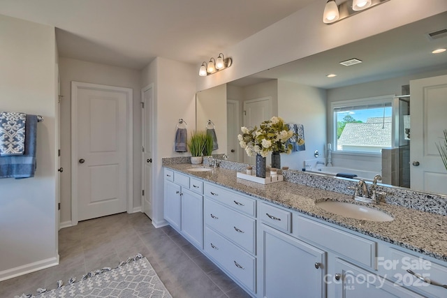bathroom with a bath, visible vents, double vanity, a sink, and a stall shower