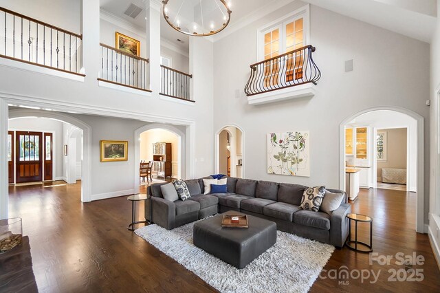 1404 Churchill Downs Dr, Waxhaw, NC 28173 - living area featuring visible vents, crown molding, dark wood-style floors, a chandelier, and arched walkways
